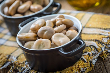 Broad beans served in black bowls.
