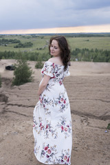 Beautiful pregnant girl in white long dress in nature