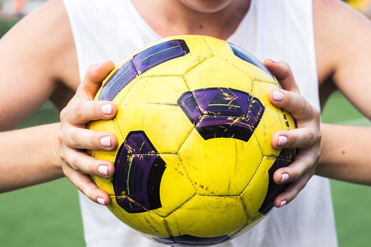 woman holding a soccer ball in her hands