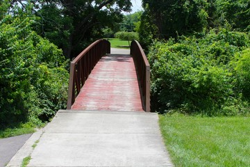 Fototapeta na wymiar The red metal bridge in the park.