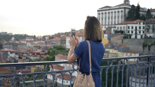 Woman taking photo of Porto view with cellphone, super slow motion 120fps
