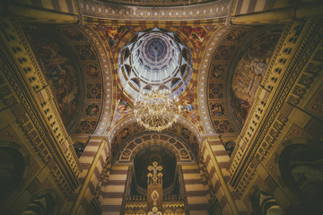 Famous orthodox Church of the Three Saints in Chernivtsi city, Ukraine. Interior with golden decoration and big chandelier