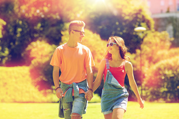 happy teenage couple walking at summer park