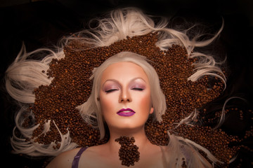 beautiful blonde woman lying with coffee beans top view fashion portrait