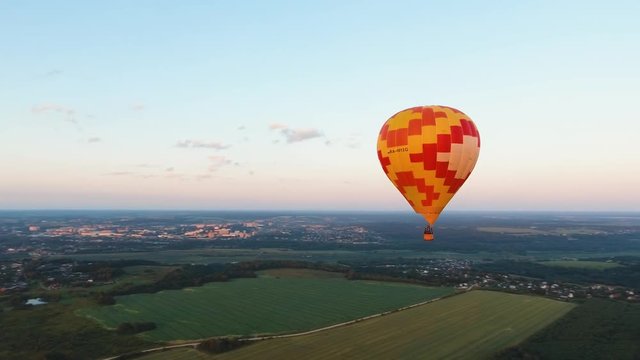 Aerial view Hot air balloon in the sky over a field in the countryside in the beautiful sky and sunset. Aerostat fly in the countryside. Aerial footage, 4K