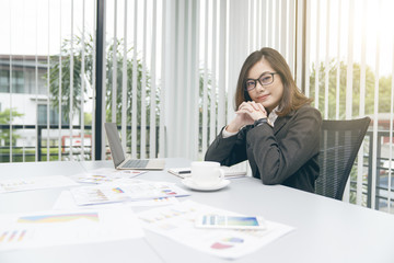 Modern asian business woman working in office with copy space and sun rise.