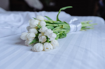 Fototapeta na wymiar Bouquet of tulips on white bed