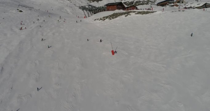 aerial drone footage  flying over skiing slopes  crowded with skiers  on beautiful slopes at  fresh snow on beautiful winter day
