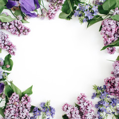 Frame of lilac flowers, branches, leaves and petals with space for text on white background. Flat lay, top view