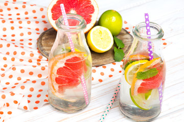 Infused flavored water with fresh fruits on white wooden background.Refreshing summer homemade  detox water