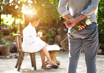 Romantic concept with man holding white rose and ring making marriage proposal