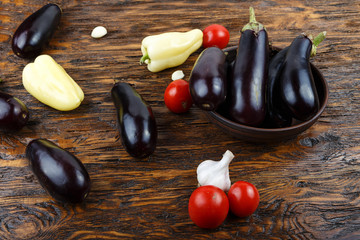Vegetables on vintage wood background - summer harvest, soup ingredients. Rural still life from above. Tomato, eggplant, garlic, pepper.top view