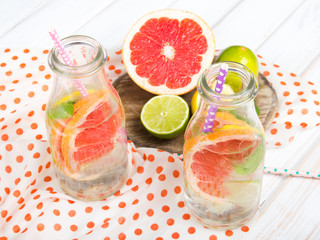 Infused flavored water with fresh fruits on white wooden background.Refreshing summer homemade  detox water
