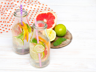 Infused flavored water with fresh fruits on white wooden background.Refreshing summer homemade  detox water