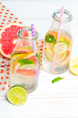 Infused flavored water with fresh fruits on white wooden background.Refreshing summer homemade  detox water
