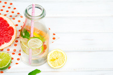 Infused flavored water with fresh fruits on white wooden background.Refreshing summer homemade  detox water