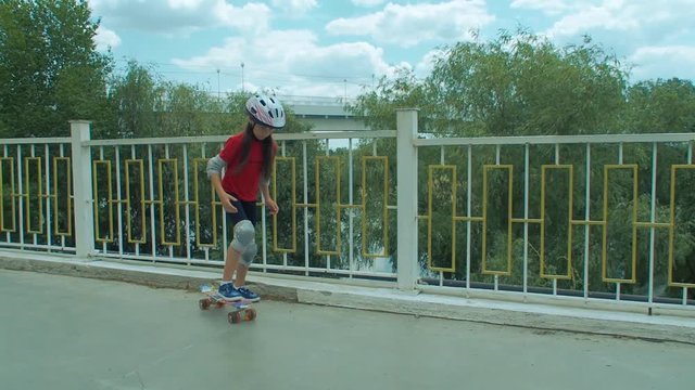 The girl skates on skateboard. The child learns to skate.