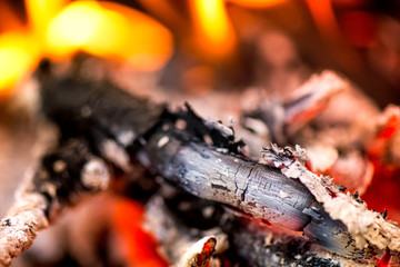 Ignite the fire. Warming up the cold winter nights. A macro shot of firewood, white dust and hot, glowing coal. Burning branches and wood. Flames in the fireplace, cozy home, warmth, love, romantic 