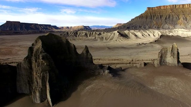 Aerial pan of layers of the desert landscape passing by viewing cliffs and peaks.