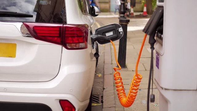 Electric car charging at UK roadside.