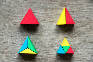 Mulit color toy block compound as triangle shape on wood background