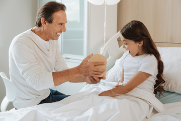 Joyful delighted man entertaining his daughter