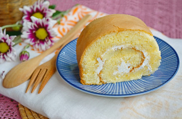 Vanilla cake roll on a plate serve with tea or coffee