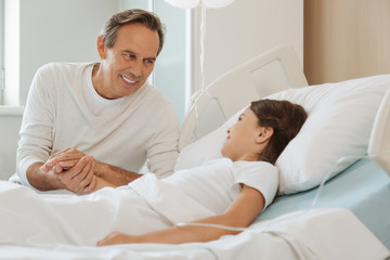 Fototapeta premium Joyful positive father smiling to his daughter