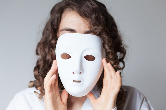 woman putting a white mask on her face