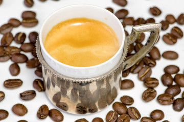 Cup of coffee and beans at backrounds