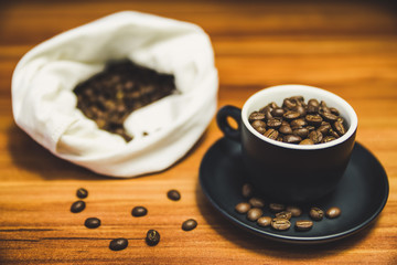 Cup of coffee and bag of beans at backrounds