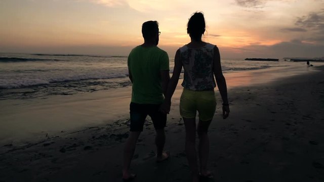 Couple in love holding hand and walking on beach during sunset, super slow motion 240fps
