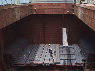 Steel billets are loading in hold of vessel by stevedore at port of  Thailand.