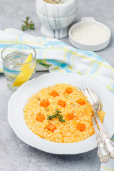 Pumpkin risotto with thyme in a white plate. Selective focus