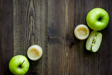 Apple puree for baby on dark wooden table background top view copyspace