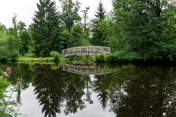 Über Wasser führende Holzbrücke mit Spiegelung