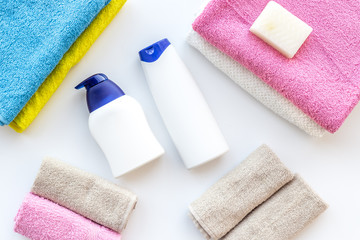 Bath accessories. Towels, soap, shampoo on white background top view copyspace
