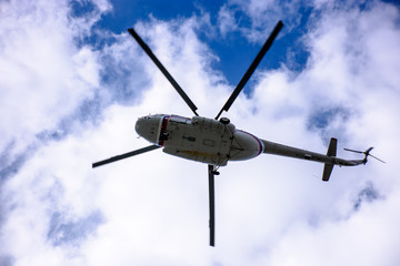 A large helicopter is flying in the blue sky