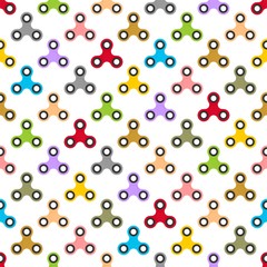 Background from color children fidget spinners on white background. Playing backdrop of hand twisting toys with bearings in a row next to each other and alternately under him 