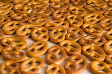 Background texture of salted savory mini pretzels in the traditional looped knot shape. Top view full frame from overhead.