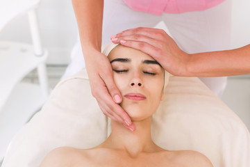 Fototapeta na wymiar Facial massage beautiful girl. Portrait of a girl in a massage parlor. 