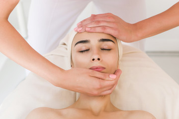 Fototapeta na wymiar Beautician doing massage of female faces.