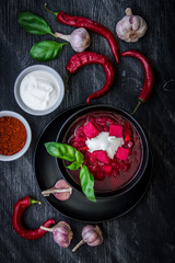 A plate of the national Ukrainian dish on a black wooden background. Borscht