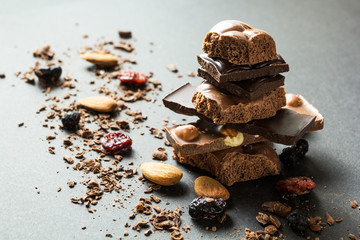 Pyramid of chocolate and dried fruits on a black background.