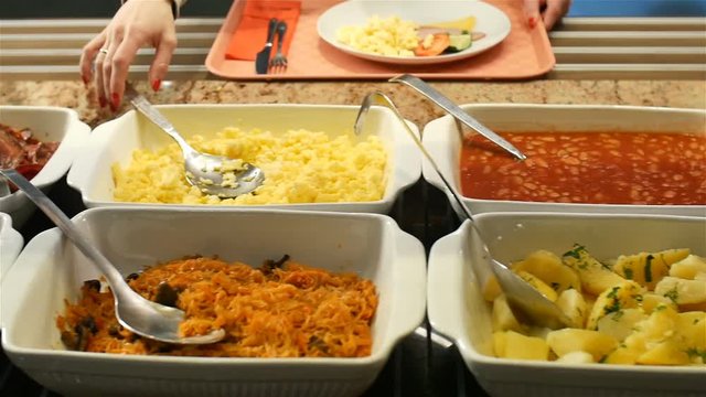 Restaurant guests select food from a buffet hd