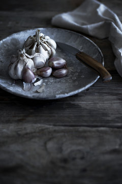 Fresh garlic on a plate in a vintage kitchen