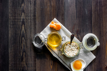 Sweet summer breakfast. Oatmeal, oranges, honey, sugar on wooden table background top view copyspace