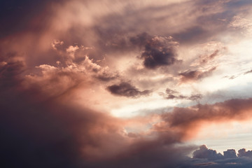 Colorful and saturated background of the setting sun sky with vivid clouds close up