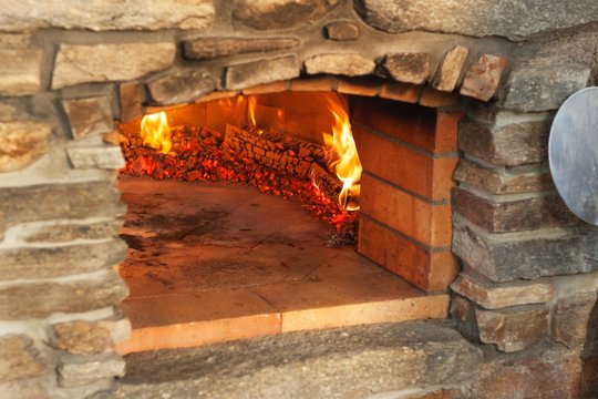 Home outdoor stone pizza oven. Traditional pizza production. Preparation of dinner.