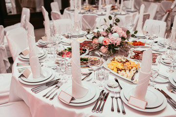 Beautifully organized event, glasses at served festive white table ready. Banquet, wedding decor. Cutlery and crockery